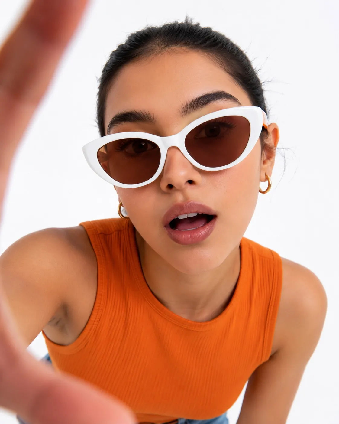 Woman in white cat-eye sunglasses and an orange top