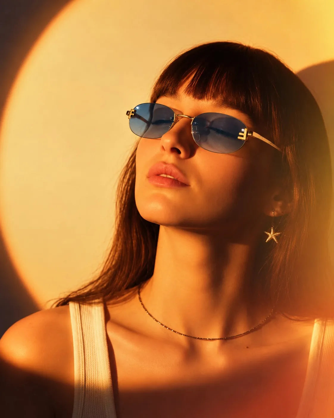 Woman in blue-tint gold sunglasses in warm light