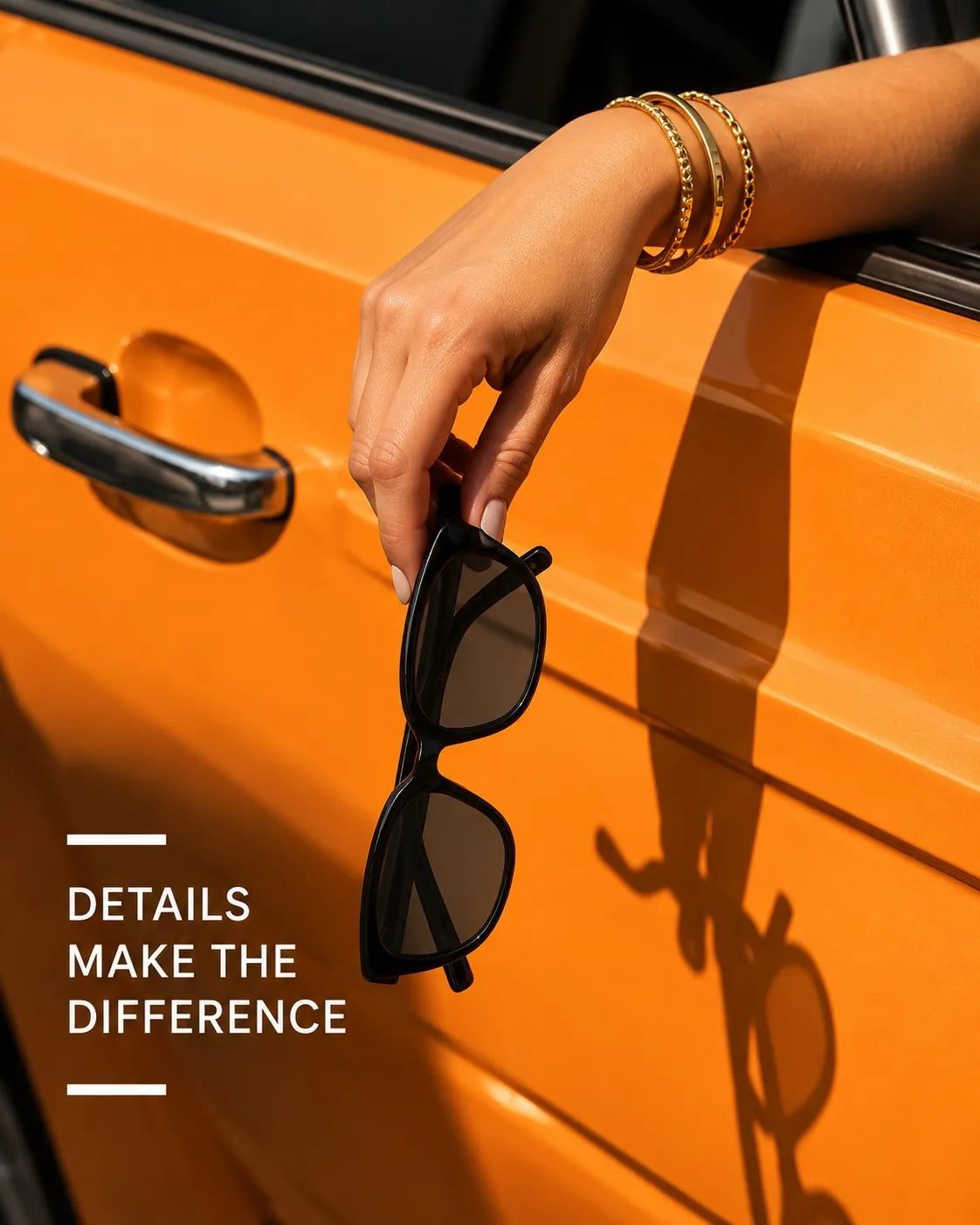 Black sunglasses held out of an orange car window